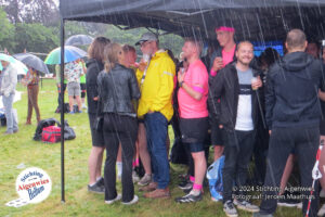 Met zijn allen schuilen tegen de regen onder de partytent van de wedstrijdleiding